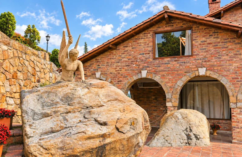 Exterior de cabaña de ladrillo con escultura